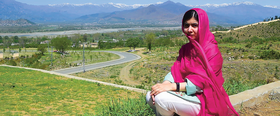Photo of Malala posing on a hilltop