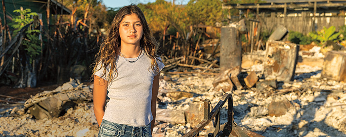 Image of a kid standing in front of rubble