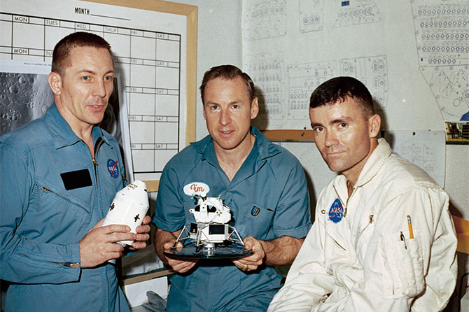 Enlargeable photo of three men in NASA uniforms holding spacecraft models