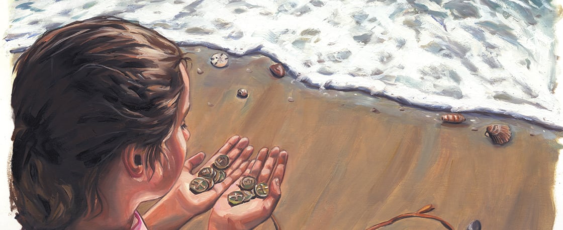 A girl standing on the beach holding old metal coins in her hands