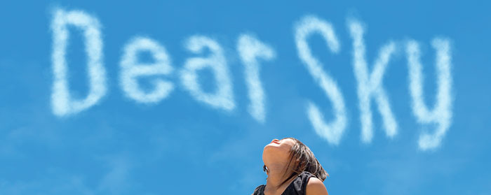 A child looking up at the sky and the text "Dear Sky"